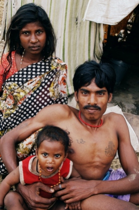 Mom, dad and their little offspring, a family living in a makeshift hut.